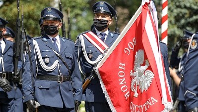 Poles stand by men and women in blue uniforms.